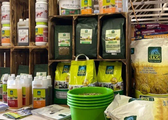 Produktausstellung von LEXA Verschiedene Produkte von LEXA, darunter Futtermittel und Pflegeprodukte für Tiere, in einem Verkaufsregal angeordnet.